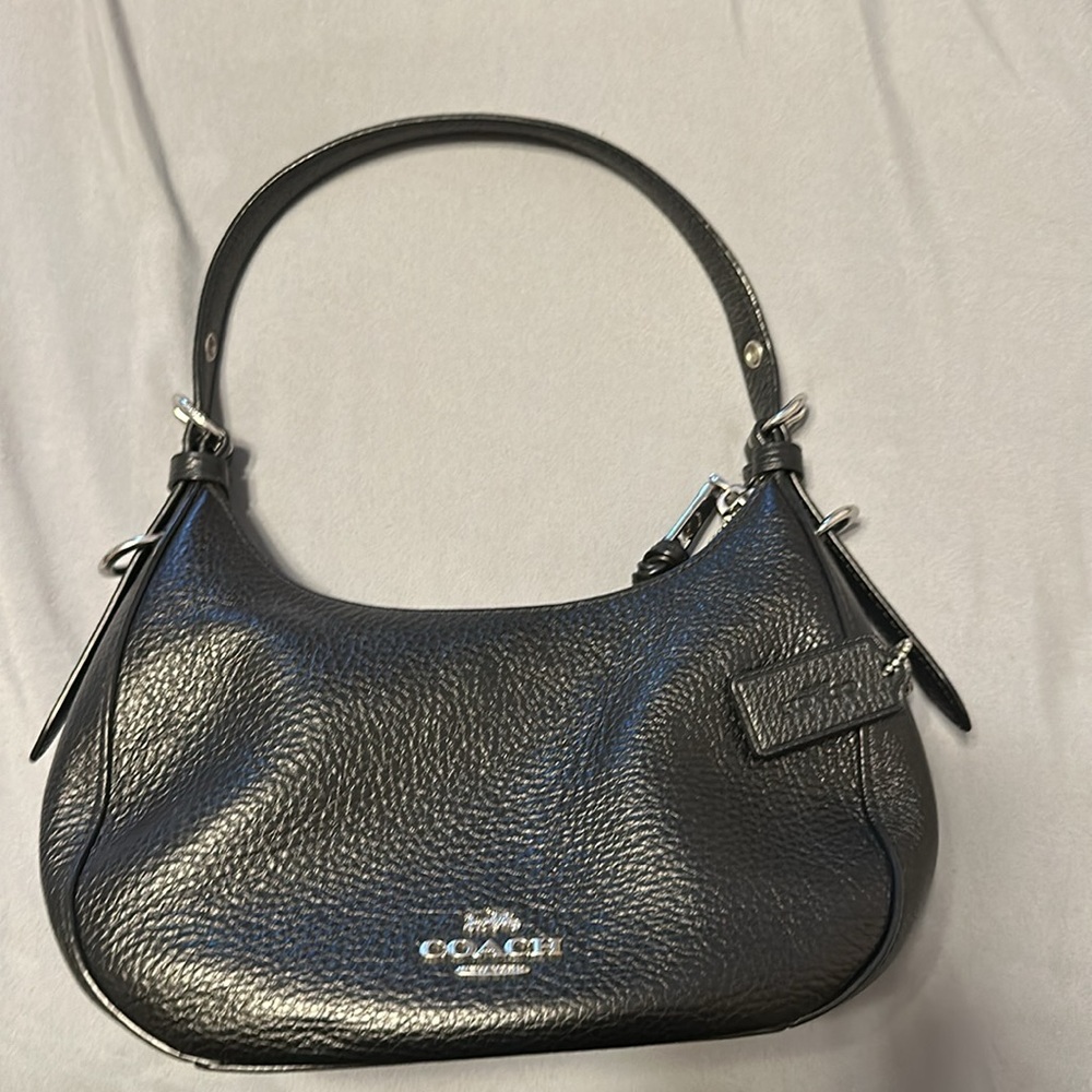 Authentic mini coach purse.Black leather with one small pocket inside.